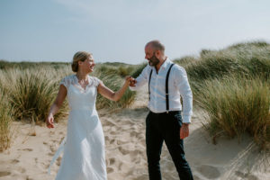 Brautpaar spaziert Hand in Hand über sandigen Weg im Grünen – Hochzeitsfotografin Köln begleitet echte Momente.