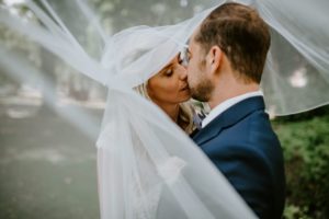 Brautpaar im Park unter zartem Schleier, festgehalten von Hochzeitsfotografin Köln bei natürlichem Licht.