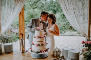 Brautpaar schneidet gemeinsam die Hochzeitstorte bei ihrer standesamtlichen Trauung in NRW.