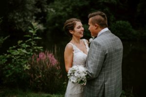Braut und Bräutigam lächeln sich im Grünen an, eingefangen von Hochzeitsfotografin Düsseldorf.
