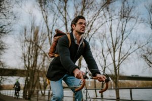 Ein Mann mit Brille radelt am Rhein entlang, spontaner Moment für die Hochzeitsreportage NRW.