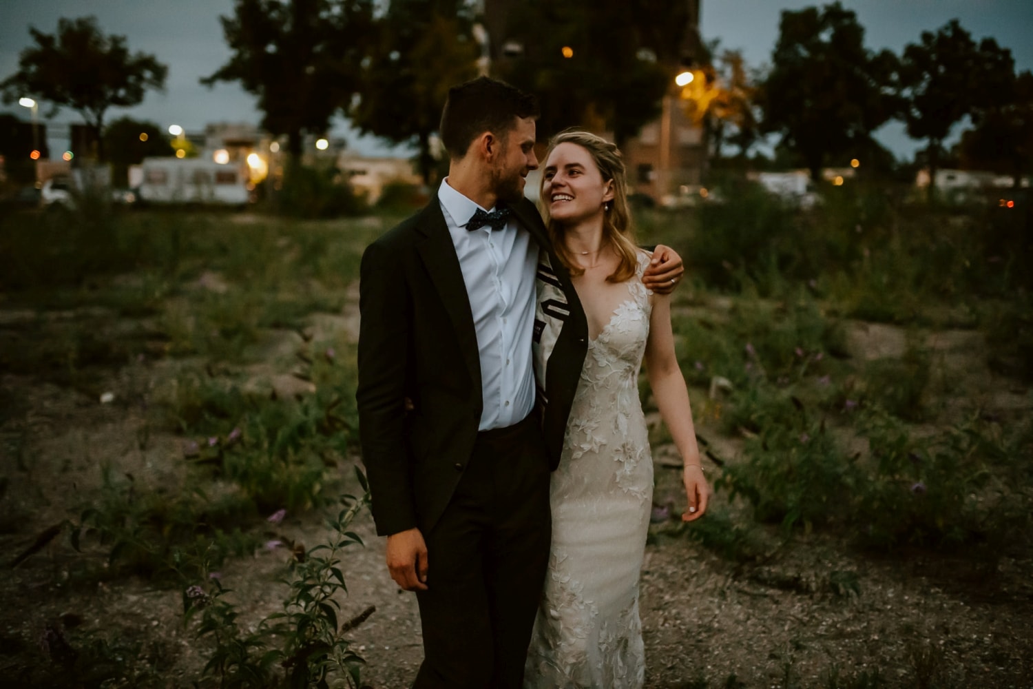 Brautpaar spaziert Hand in Hand bei ihrer standesamtlichen Trauung in Bonn im Abendlicht.