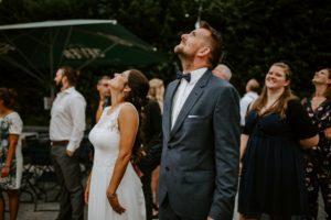 Freunde und Familie lachen gemeinsam nach oben – echte Hochzeitsreportage NRW Momentaufnahme.