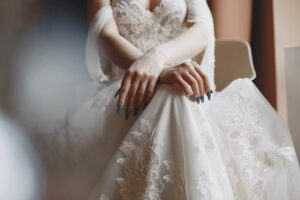 Braut im Spitzenkleid bei ihrer standesamtlichen Trauung, Hände ruhig im Schoß – Hochzeitsreportage NRW.