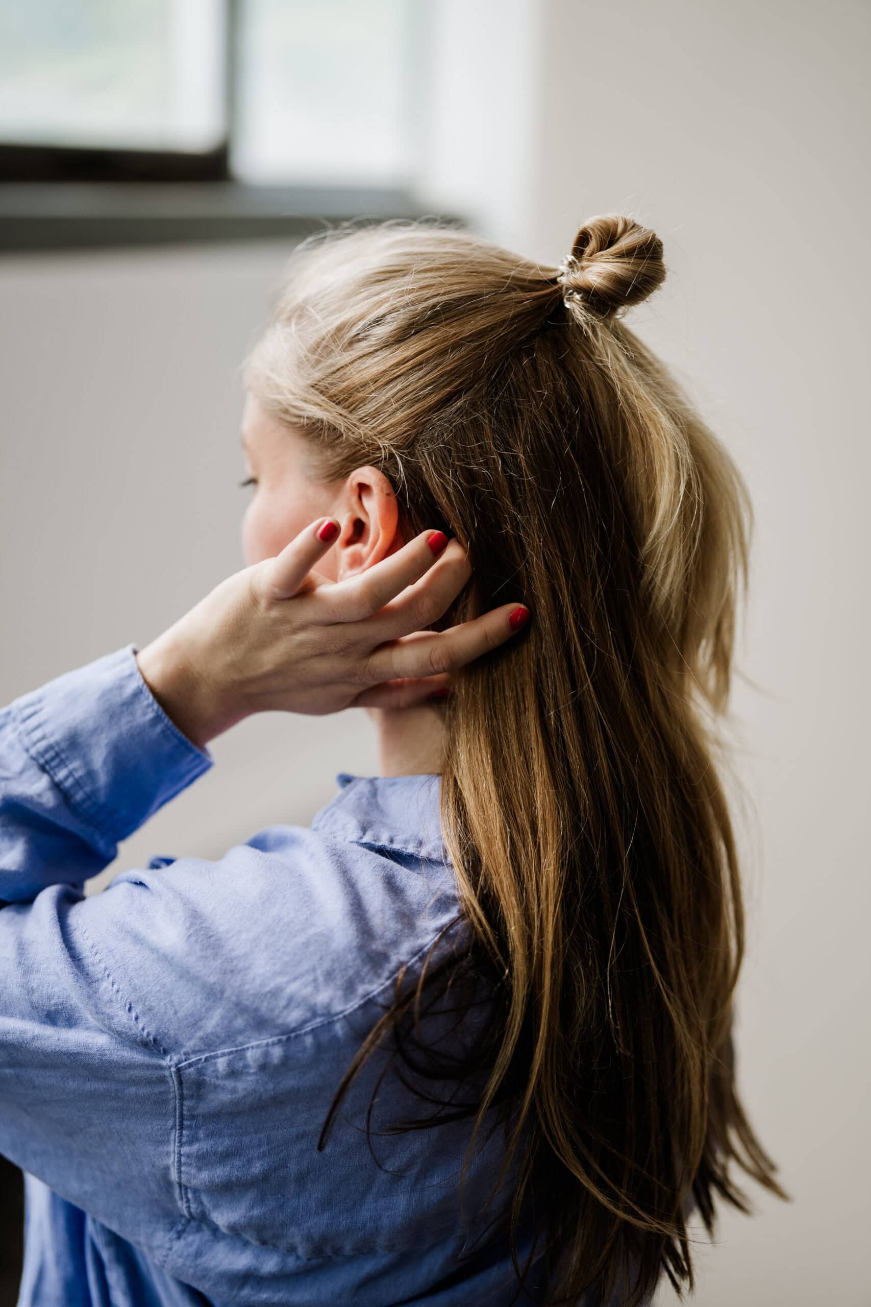 Hochzeitsfotografin Vera streicht sich Haare nach hinten beim Shooting in Köln