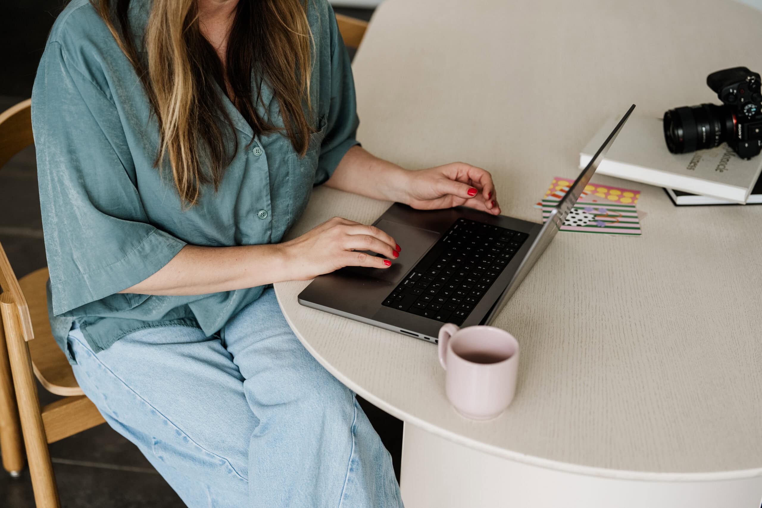 Eine Hochzeitsfotografin Bonn plant ihre nächste Hochzeitsreportage am Laptop mit Kaffee und Notizen.