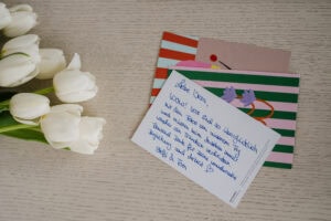Weißer Tulpenstrauß und handgeschriebene Hochzeitspostkarten, Ausschnitt aus einer Hochzeitsreportage in NRW.