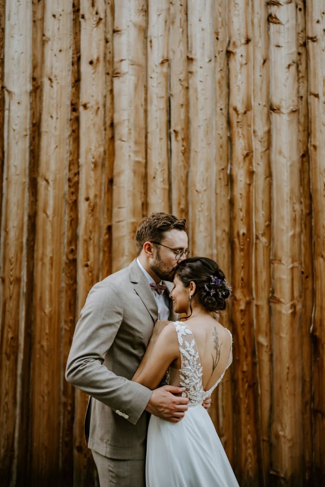 Inniger Moment vor Holzwand – Brautpaar bei Hochzeit an der Holsteins Mühle, NRW