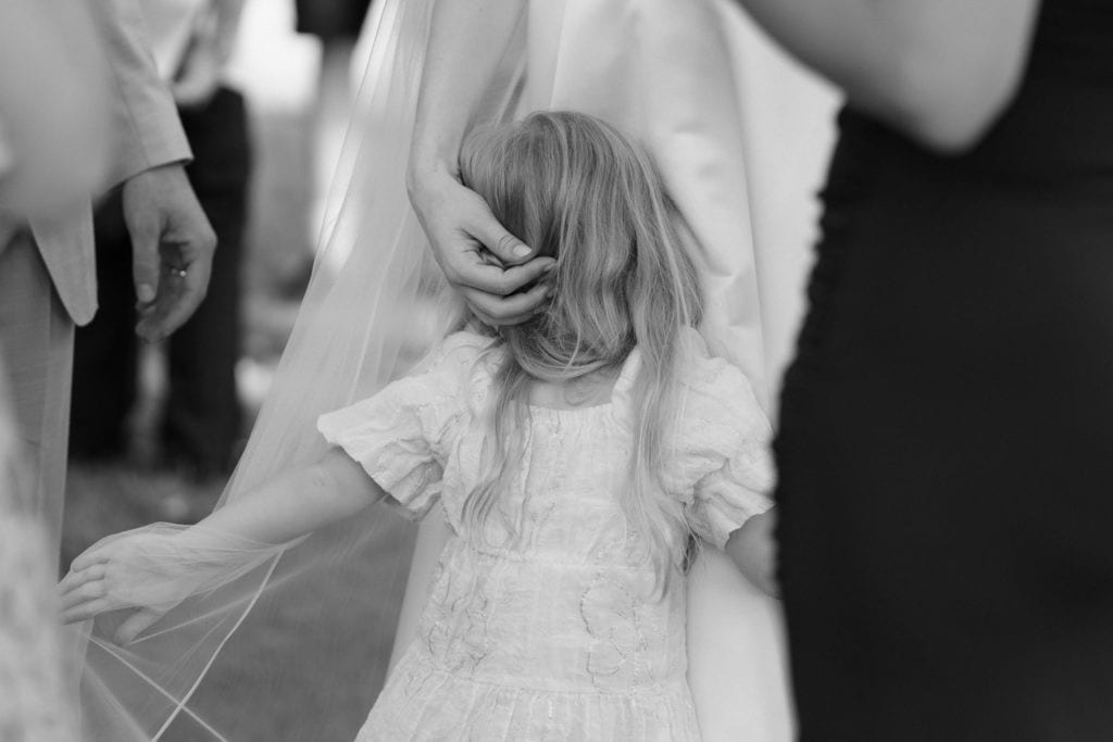 Kind hält den Schleier der Braut während der Hochzeit
