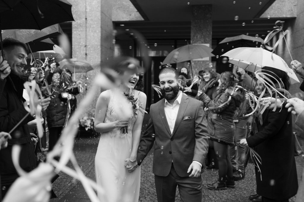 Hochzeitspaar beim Auszug nach der standesamtlichen Trauung in Köln, begleitet von Gästen